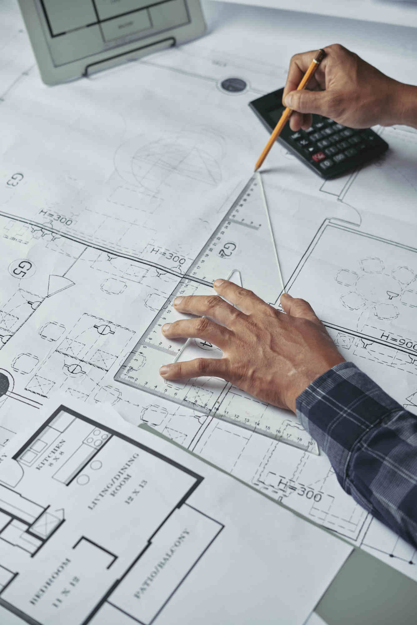 Hands of architect drawing blueprint of the house